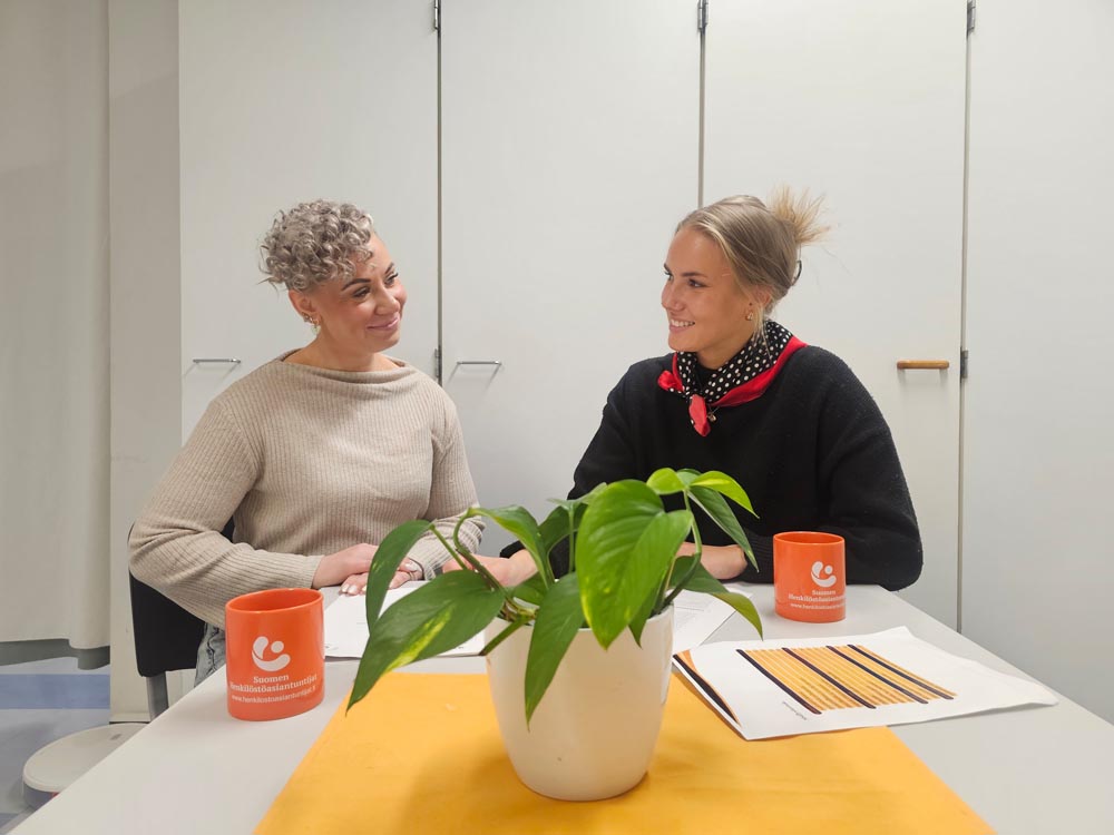 Uramahdollisuuksien analyysi Kaksi naista keskustelee pöydän ääressä valmennustilanteessa työelämän uramahdollisuuksista.