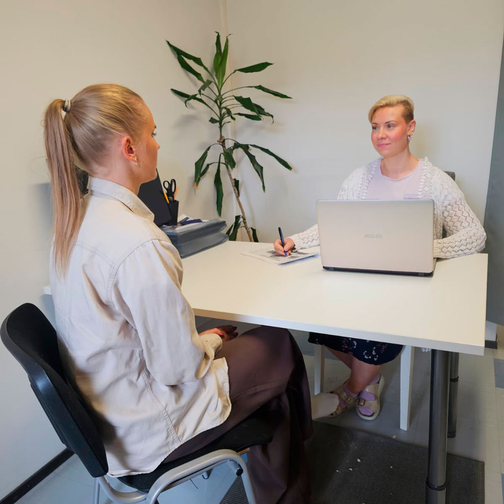 Henkilöstöasiantuntija haastattelee työnhakijaa toimistossa työpöydän ääressä.
