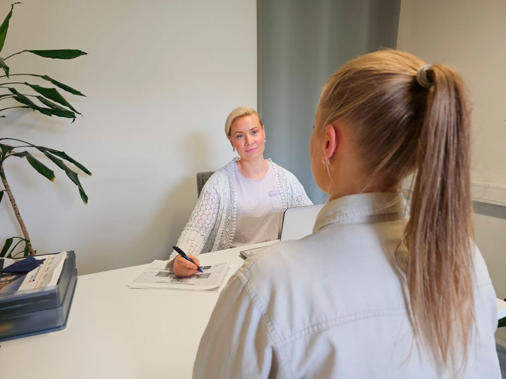 Oppilaitosyhteistyö Kaksi naista keskustelee työhaastattelussa pöydän ääressä toimistossa.