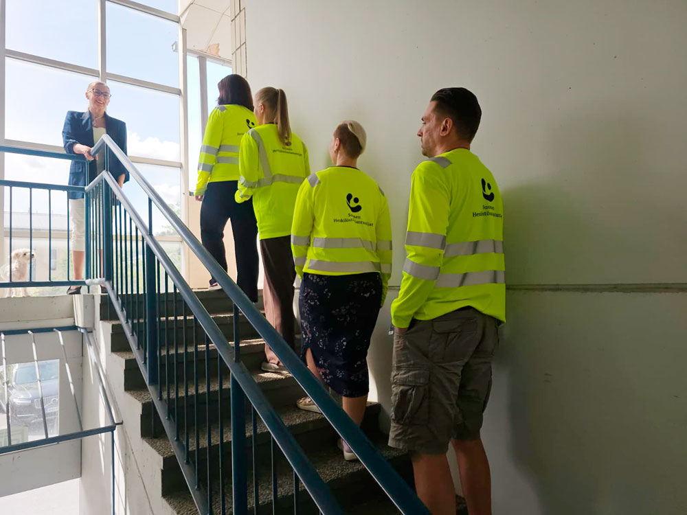 Rekrytoinnissa kulkeva työnhakijaryhmä nousee portaita asiantuntijan johdolla.